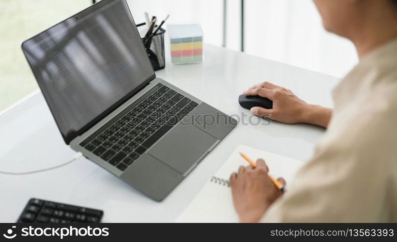 Developer programmer use mouse and checking code on laptop while programming to developing website.