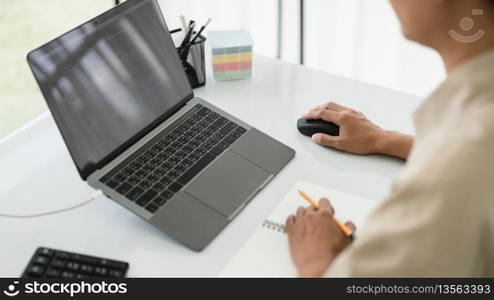 Developer programmer use mouse and checking code on laptop while programming to developing website.