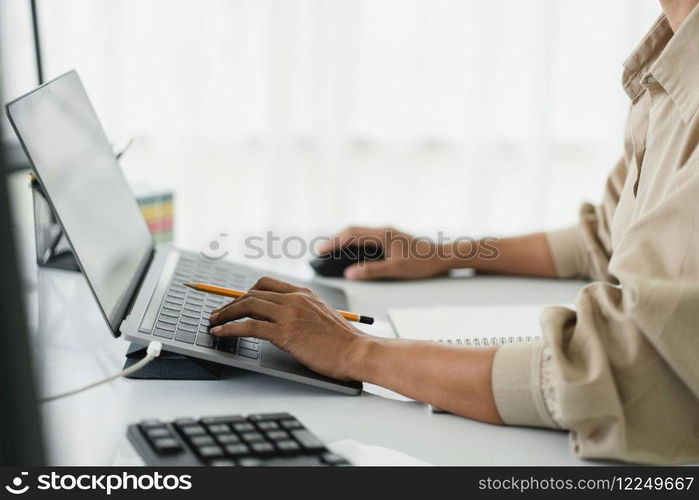 Developer programmer using mouse and typing code on laptop while programming to developing website.