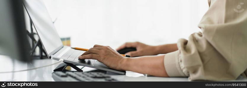 Developer programmer using mouse and typing code on laptop while programming to developing website.