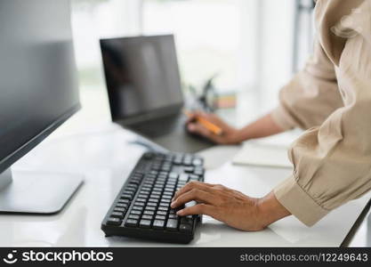 Developer programmer working on computer and laptop while programming code to developing website.