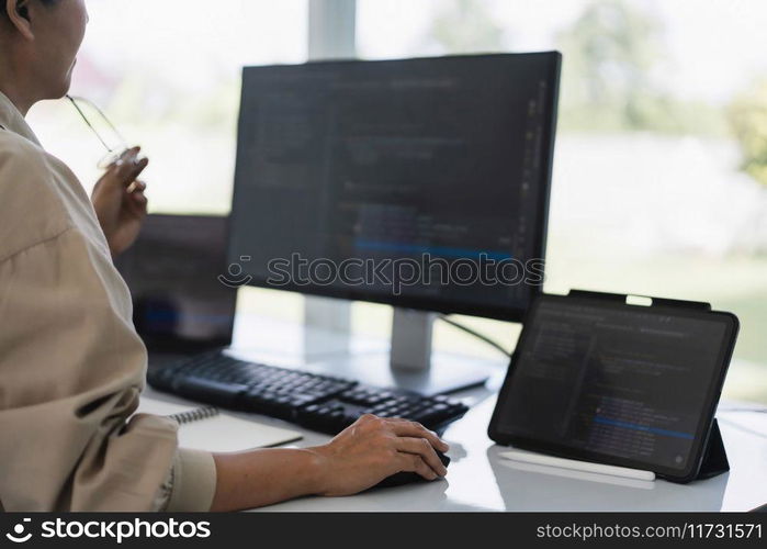 Developer programmer working to checking code on monitor while programming to developing website.