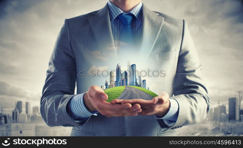 Development project. Close up of businessman holding city model in hands