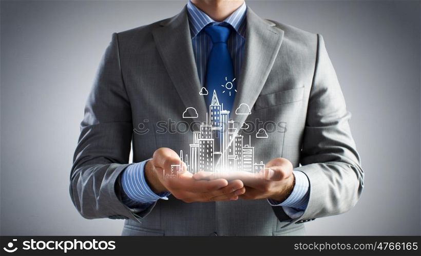 Development project. Close up of businessman holding city model in hands