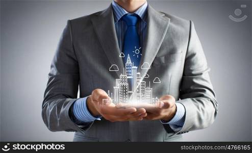 Development project. Close up of businessman holding city model in hands