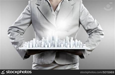 Development project. Close up of businesswoman hands presenting building model