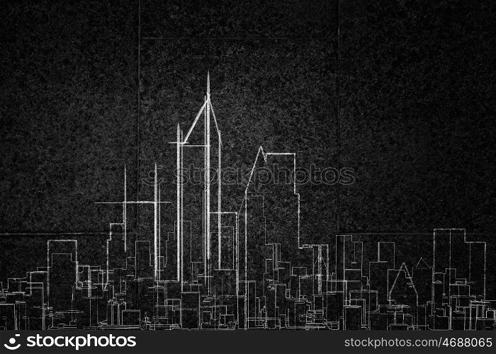 Development project. Close up of hand drawing urban city building on chalk board