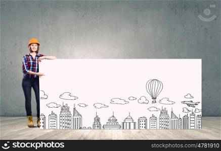 Development project. Young woman builder wearing helmet and holding banner with construction sketches