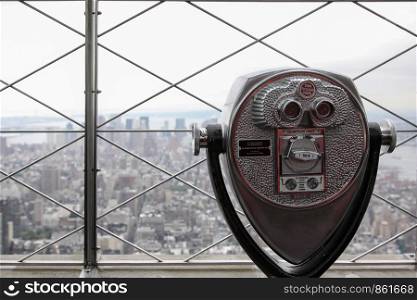 Device binoculars with money on high rise in New York