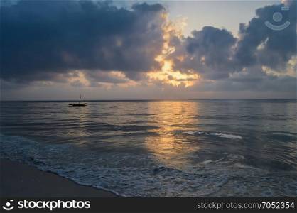 Dhow on the ocean at sunrise . Dhow on the ocean at sunrise on Bamburi beach in Kenya