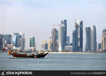 Dhows moored side-by-side in Doha Bay, in front of the constantly emerging city skyline, with recently completed towers and others still under construction. The wealthy Arab emirate has been in the grip of an oil- and gas-revenues fuelled construction boom ever since the turn of the century.