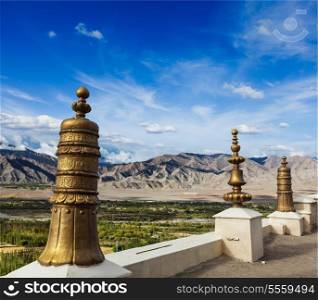 Dhvaja (victory banners), on the roof of Thiksey gompa (Tibetan BUddhistm monastery) and view of Indus valley. Ladakh, India