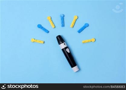 Diabetes concept on blue background. An abstract clock made of interchangeable needles and a lancet for blood sugar testing.. Diabetes concept on blue background. An abstract clock made of interchangeable needles and a lancet for blood sugar testing