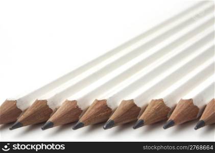 Diagonal row of white pencils isolated on white background with copy space.