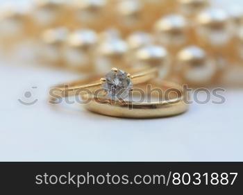 Diamond engagement ring and wedding band, pearls in the back