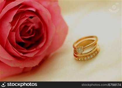 Diamond wedding rings and plain band and pink rose