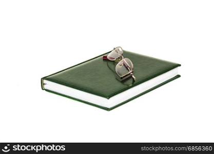 Diary and eyeglasses lie on a white background
