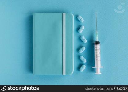 diary pills syringe blue surface