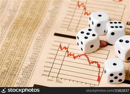 Dice and stock market charts in the newspaper