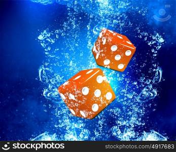 Dice cubes under water. Conceptual image with dice cubes in clear blue water