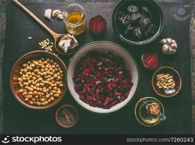 Diced beet and salad ingredients with pine nuts, chickpeas and prunes on dark background, top view with copy space for your design. Healthy , low calories food and diet and detox eating concept