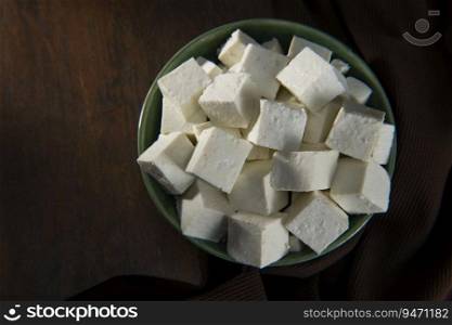 Diced Paneer or cottage cheese in a green bowl