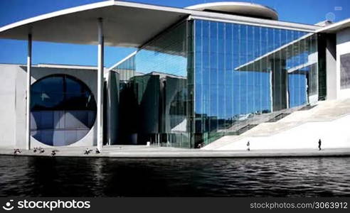 Die Szene zeigt den Berliner Regierungsbezirk mit dem Marie-Elisabeth-Luders-Haus, im Vordergrund ist die Spree zu sehen