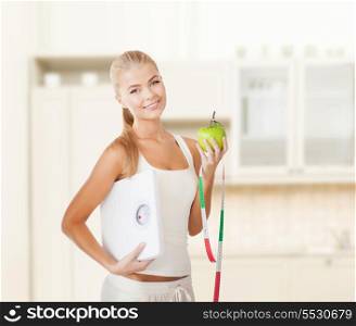 diet and fitness concept - beautiful sporty woman with scale, green apple and measuring tape