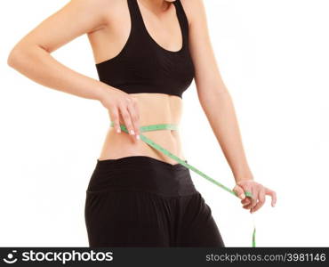 diet and healthy lifestyle. closeup of belly of slim fit girl young woman with green measure tape measuring her waist isolated on white