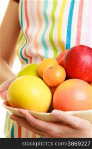 Diet and nutrition. Closeup housewife or seller in striped kitchen apron offering healthy fruits isolated