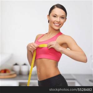 diet and sport concept - beautiful sporty woman measuring her breast