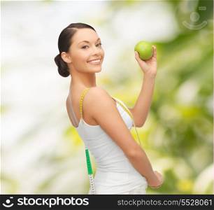 diet and sport concept - beautiful sporty woman with apple and measuring tape