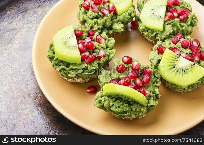 Diet avocado cupcakes garnished with kiwi and pomegranate.American food.. Cupcake with avocado cream.