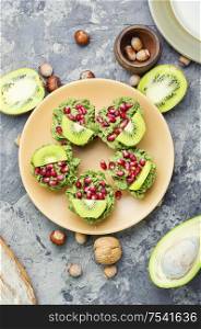 Diet avocado cupcakes garnished with kiwi and pomegranate. Cupcakes from avocado and kiwi.
