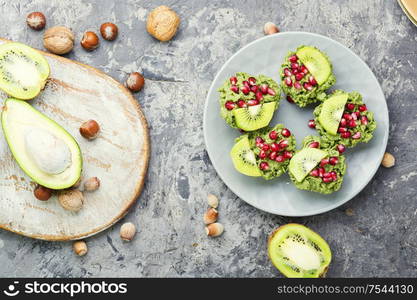 Diet avocado cupcakes garnished with kiwi and pomegranate.Fairy cake. Cupcakes from avocado and kiwi.