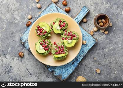 Diet avocado cupcakes garnished with kiwi and pomegranate.Fairy cake. Tasty cupcakes from kiwi.