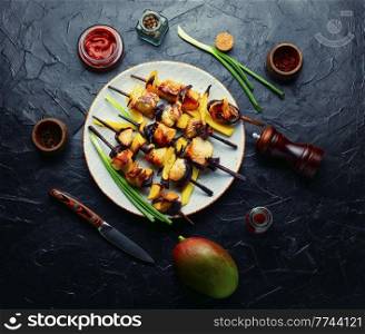 Diet chicken skewer with ripe mango. Shashlik, top view. Chicken kebabs, skewered chicken