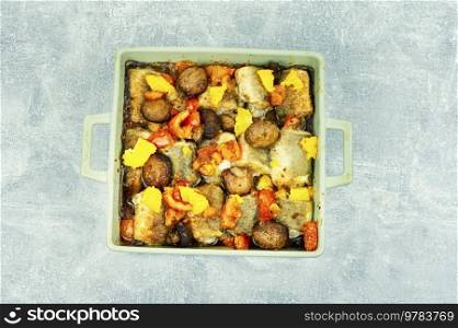 Diet fish hake cooked with mushrooms, orange and tomatoes.. White fish baked with vegetable and oranges, flat lay