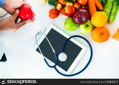 Diet food of fruit and vegetables for cholesterol control with nutritionist hands showing awareness and prevention of heart disease. Healthy eating and good nutrition concept.