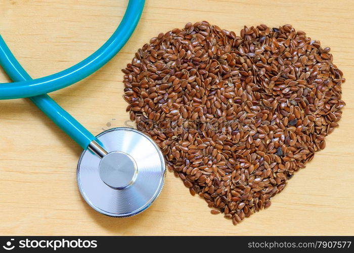 Diet healthcare and checkup concept. Raw flax seeds linseed heart shaped and stethoscope. Healthy food for preventing heart diseases.