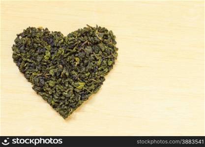 Diet healthcare concept. Green tea heart shaped on wooden surface. Healthy food drink for lower heart disease risk