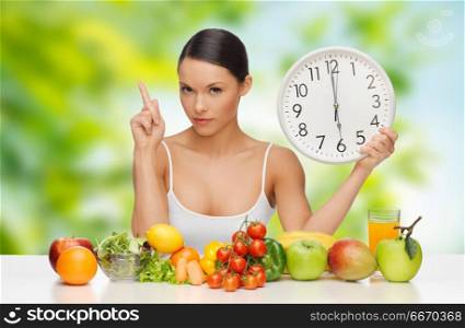 diet, healthy eating and people concept - woman with food and clock showing six warning over green natural background. woman with food and clock showing six. woman with food and clock showing six