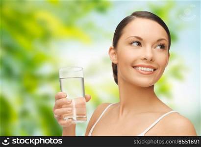 diet, healthy eating and people concept - woman with glass of water over green natural background. woman with glass of water. woman with glass of water