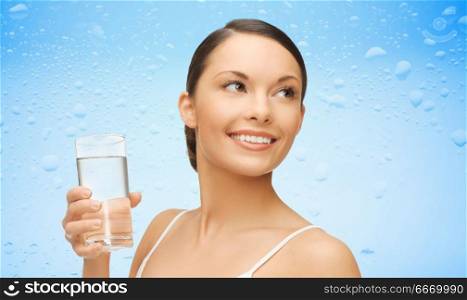 diet, healthy eating and people concept - woman with glass of water over wet blue background. woman with glass of water over wet blue background. woman with glass of water over wet blue background