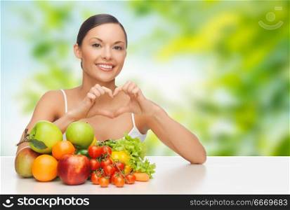 diet, healthy eating and people concept - woman with vegetable food showing hand heart gesture over green natural background. woman with vegetables showing hand heart. woman with vegetables showing hand heart