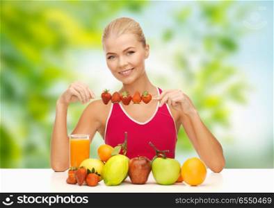 diet, healthy food and people concept - woman with fruits and juice eating strawberry over green natural background. woman with fruits and juice eating strawberry. woman with fruits and juice eating strawberry
