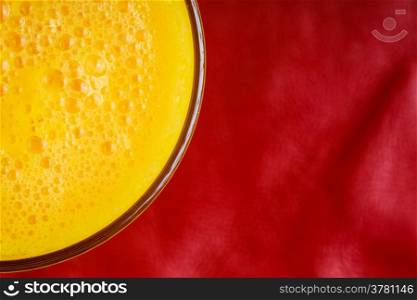 Diet healthy nutrition. Closeup of fresh summer drink yellow fruit juice on red background
