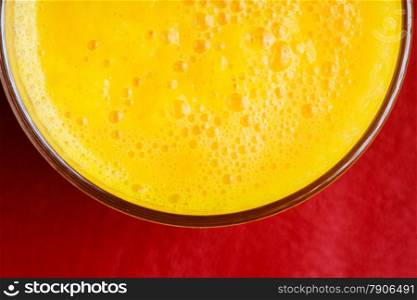 Diet healthy nutrition. Closeup of fresh summer drink yellow fruit juice on red background