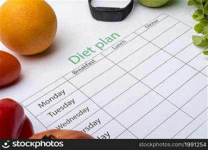 Diet plan sheet and fresh food on white background. Top view, the concept of healthy eating.. Diet plan sheet and fresh food on white background.