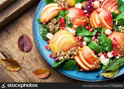 Diet salad of apples,cheese,arugula and oatmeal.Healthy salad on rustic wooden table. Vitamin salad with apple,herbs and oatmeal